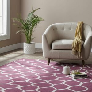 A berry and cream geometric trellis rug grounds a space with a light gray armchair on wood floors.