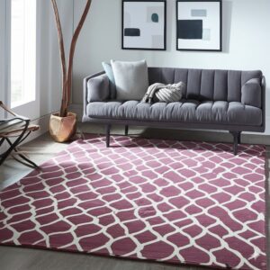 Burgundy and cream lattice rug on gray wood floor beneath a modern channel-tufted gray sofa.