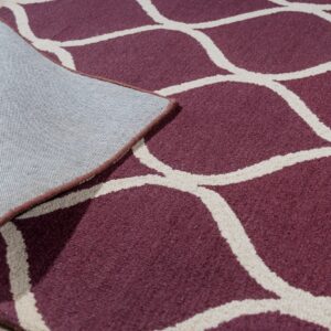 Low-pile maroon rug with a cream geometric pattern is lifted, showing the gray woven backing on light wood floor.