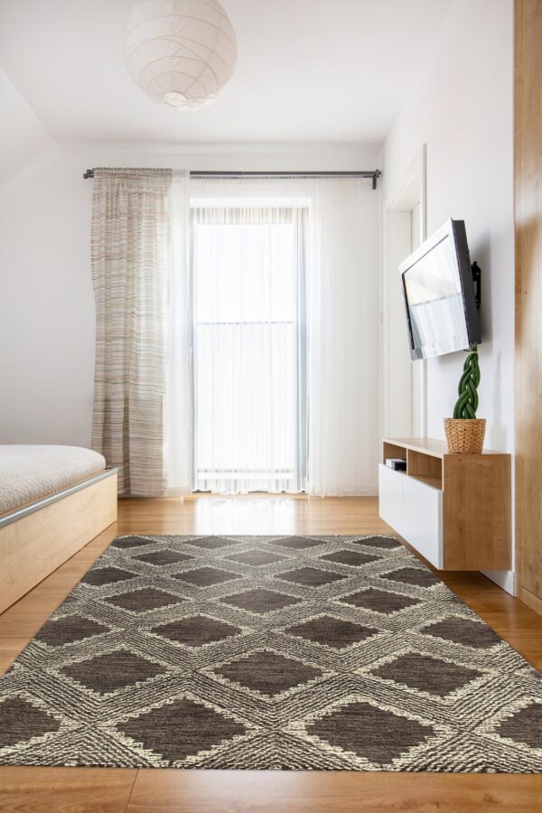 A dark brown diamond geometric rug is placed on a light wood floor in a brightly lit room.
