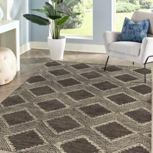 Textured brown and beige diamond patterned rug on wood plank flooring near a gray armchair.