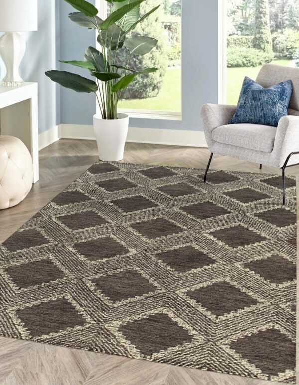 Textured brown and beige diamond patterned rug on wood plank flooring near a gray armchair.