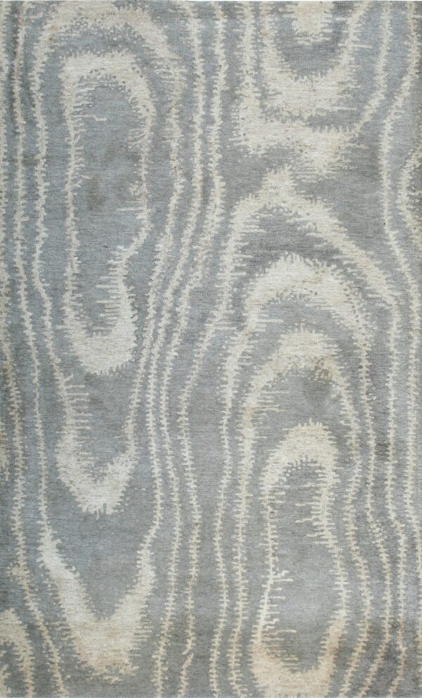 Plush blue-gray rug featuring a frayed abstract pattern in cream and light beige.