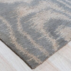 High-pile gray and beige abstract rug displaying a distressed pattern on pale wood flooring.