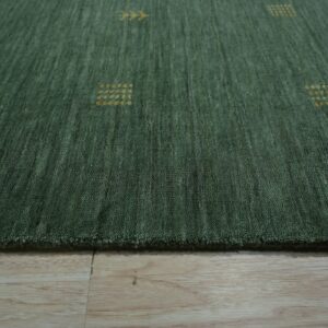 Textured deep green rug with scattered yellow geometric patterns resting on light wood plank flooring.