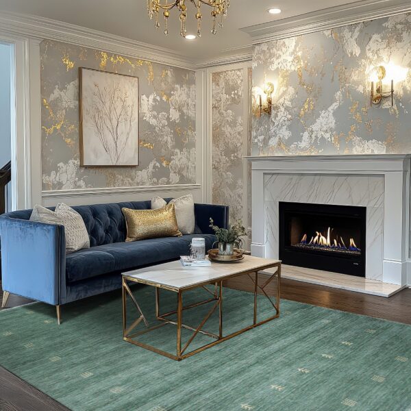 Teal low-pile rug with geometric accents anchors a room featuring a blue sofa and gold metallic wallpaper.