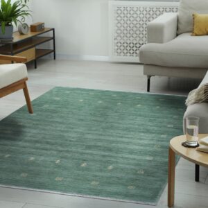 Striated teal rug with scattered small light motifs anchors a bright living room with neutral furniture.