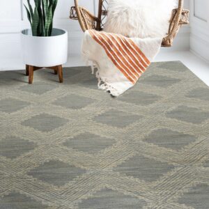 A low-pile gray and beige diamond pattern rug sits beneath a wicker hanging chair and a potted snake plant.