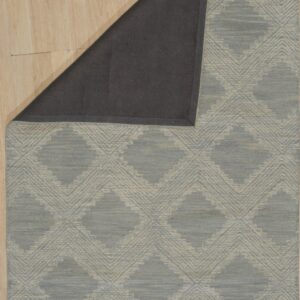 Low-pile blue-gray and cream diamond patterned rug on wood flooring with a dark gray backing exposed.