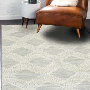 Textured cream and gray rug with diamond shapes displayed under a brown leather chair.