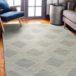 A low-pile gray and beige diamond pattern rug sits on hardwood floors between a blue chair and a gray sofa.