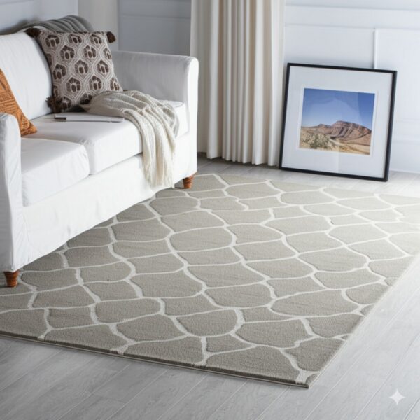 Taupe rug featuring a recessed white geometric pattern anchors a white sofa on light gray wood flooring.