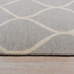 A close-up of a gray textured rug with a cream trellis pattern resting on glossy light wood planks.