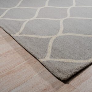 A textured gray rug featuring an off-white geometric pattern rests on light wood planks.