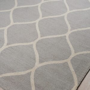 Textured gray rug with a geometric cream lattice pattern rests on light wood flooring.