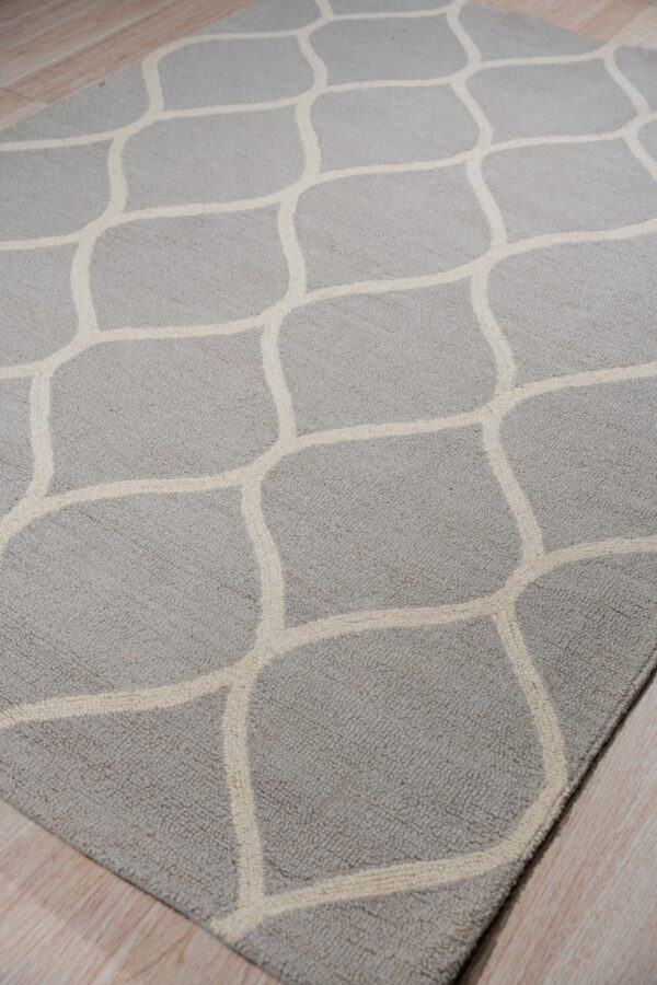Textured gray rug with a geometric cream lattice pattern rests on light wood flooring.