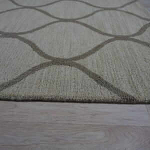 Beige textured rug featuring a contrasting curved lattice pattern rests on light wood floor.