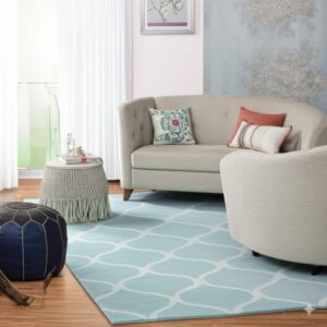 The low-pile teal rug features a white trellis pattern beneath beige upholstered furniture on wood flooring.