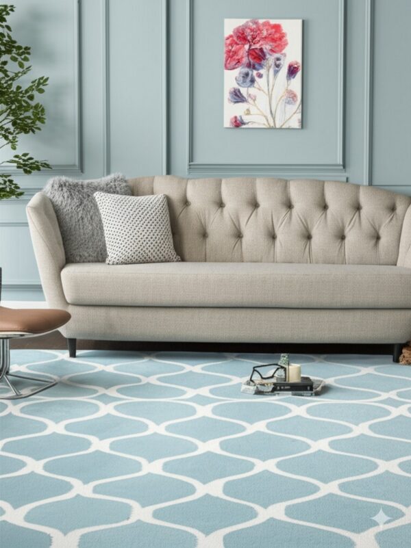 A blue and white geometric patterned rug lies beneath a tufted beige sofa and light blue paneled walls.