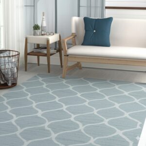 Light blue rug with a white trellis pattern covers light wood flooring in a seating area with a white bench.