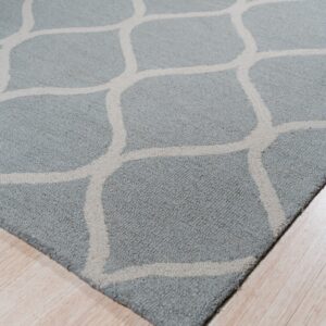 Textured blue-gray rug featuring a large-scale beige geometric trellis pattern over light wood flooring.