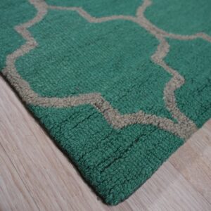 A chunky teal rug with a tan Moroccan lattice pattern rests on light wood flooring.