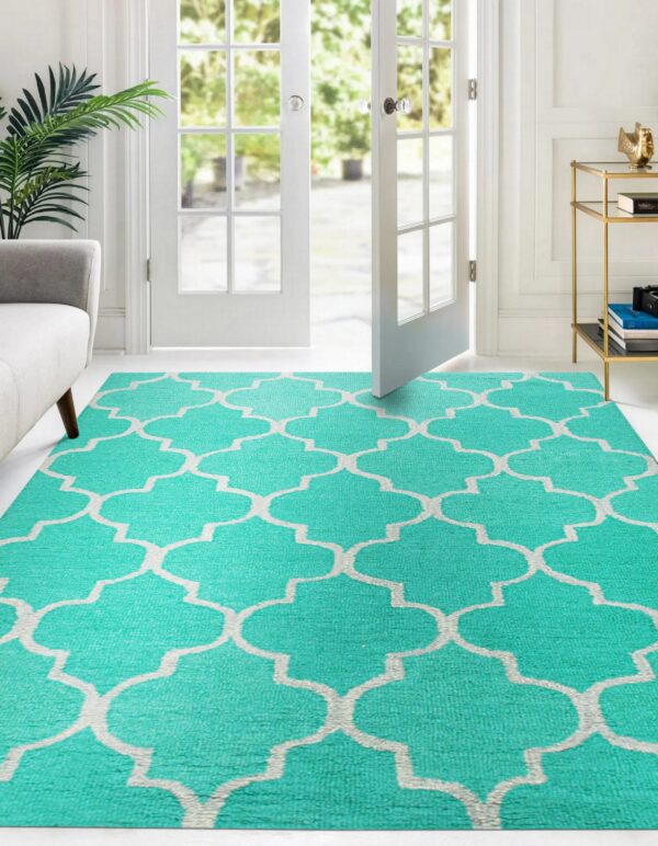 Bright aqua rug featuring a white quatrefoil pattern on a light floor near french doors.