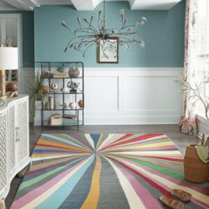A tightly woven rug with a multicolored radial striped pattern sits on grey flooring in a room with blue walls.