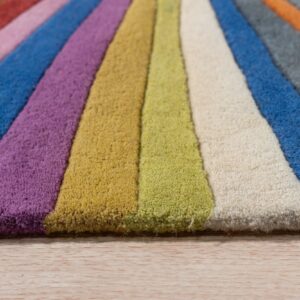 Close-up view of a multicolor striped rug with varying pile heights, resting on light wood flooring.