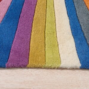 A multicolored, striped rug with a thick texture rests on light wood flooring.