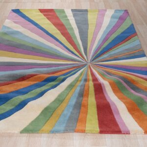 Brightly multicolored rug featuring a radial sunburst pattern of wavy stripes on light wood flooring.