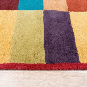 Multi-colored plush area rug featuring large blocks of yellow, purple, and green on light wood flooring.