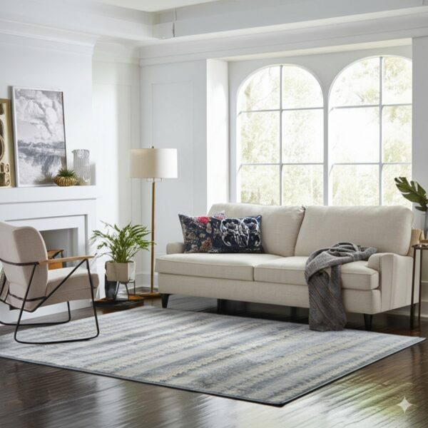 Gray and blue striated rug under a beige sofa on dark wood floors in a bright living room.