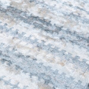 Close-up of a medium-pile rug showing an abstract pattern in white, gray, and light beige.