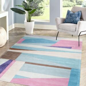 Abstract pink, blue, and brown low-pile rug on wood floors by a window and gray armchair.