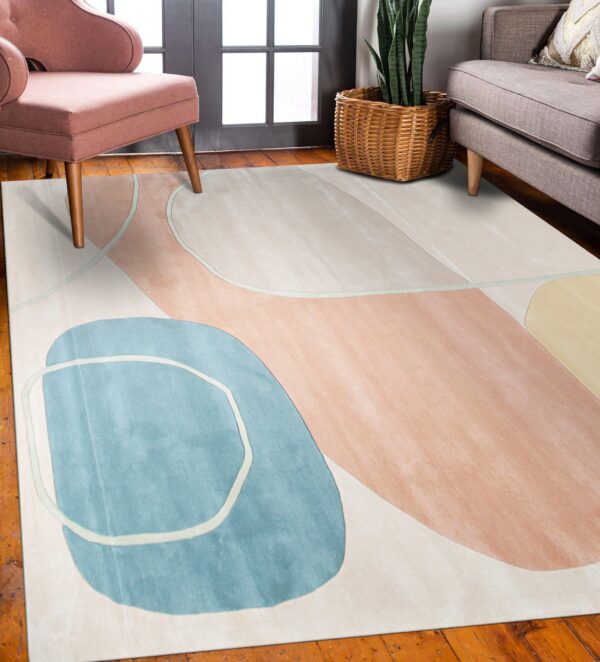 Abstract cream rug featuring blue and blush curvilinear shapes sits under a pink chair and gray sofa.