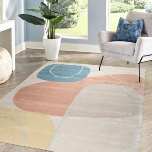 Abstract rug with blush, light blue, and yellow shapes on chevron wood flooring in a bright sunlit room.