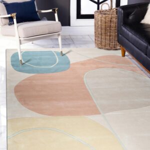Low pile rug featuring abstract shapes in blue, peach, and yellow beneath a cream armchair.