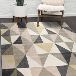 Geometric rug featuring blush, cream, gray, and olive triangles rests on a dark wood floor.