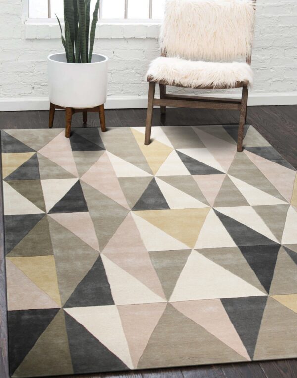 Geometric rug featuring blush, cream, gray, and olive triangles rests on a dark wood floor.