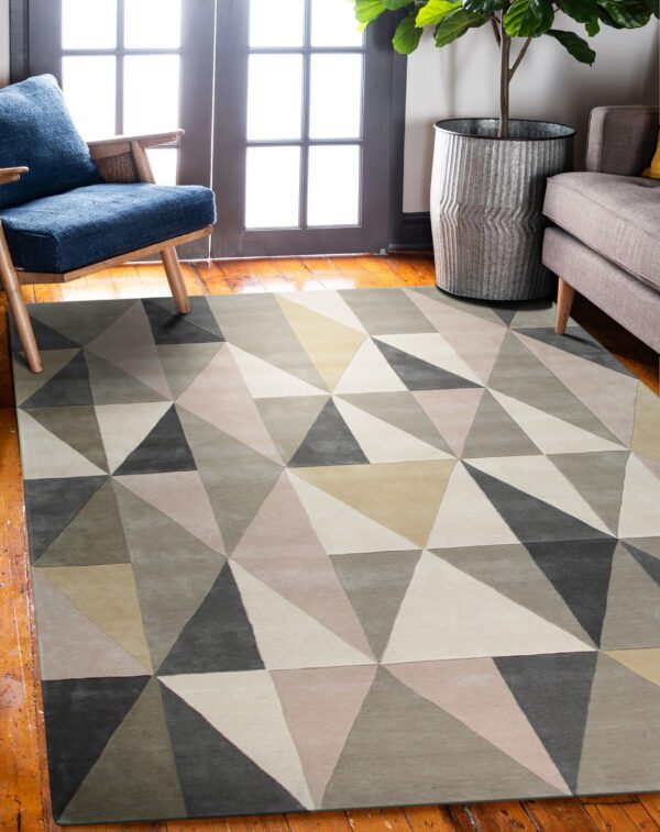 Geometric triangle rug in shades of gray and beige anchors a room with wood floors and bright doors.
