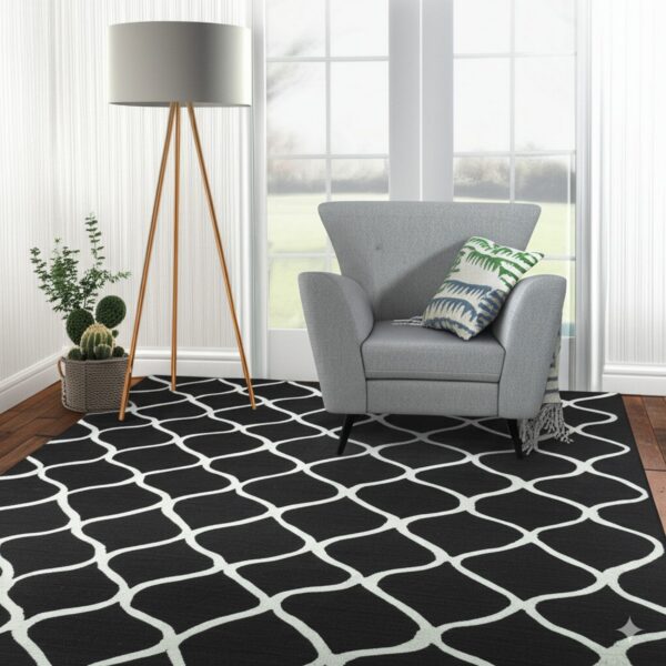 Black and white trellis rug under a gray armchair and wood tripod lamp on hardwood floors.