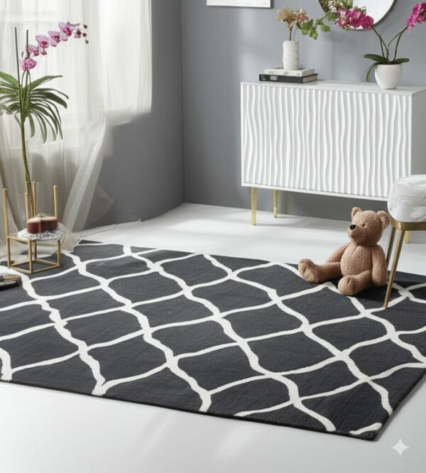 A dark gray rug with a white trellis pattern covers white flooring next to a cabinet and teddy bear.