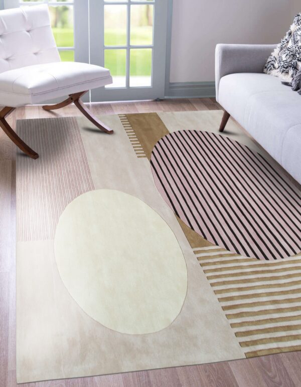 Geometric abstract rug in cream, pink, brown, and black stripes lays on wood floor with modern seating.
