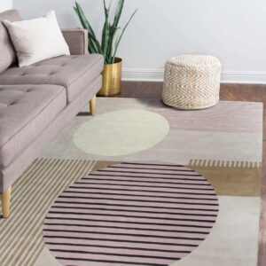 A modern rug featuring large abstract circles and stripes in beige, pink, and taupe colors on dark wood flooring.