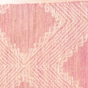 Textured pink and ivory loop-pile rug displaying a geometric pattern rests on light wooden flooring.
