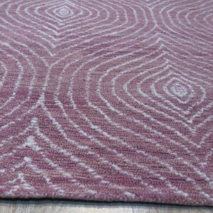 Textured mauve rug featuring white concentric diamond patterns shown on light wood plank flooring.