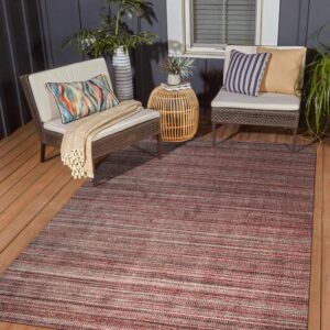 Red and gray striped low-pile rug on a wooden deck between two woven outdoor chairs.
