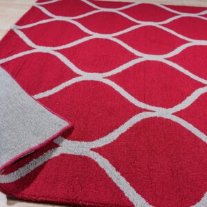 Deep red rug with a gray ogee pattern rests on light wood floor, showing the gray backing.