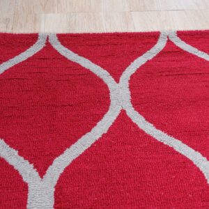Close view of a textured red rug featuring a gray geometric trellis pattern on a light wood floor.